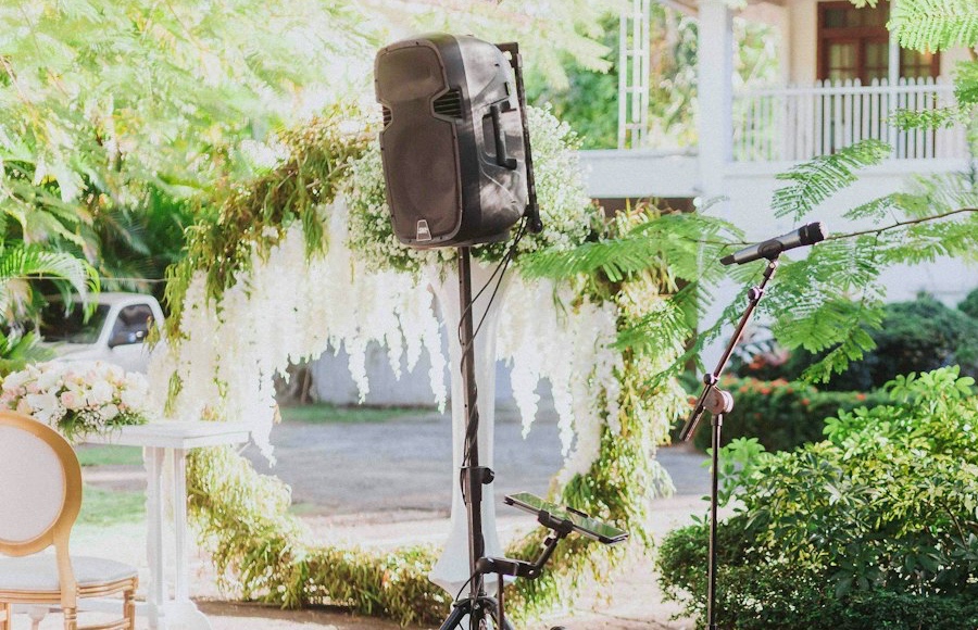 Speaker on a stand set up in a wedding garden